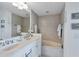 Well-lit bathroom featuring double sinks and a bathtub with neutral tile surround at 800 N Tamiami Trl # 604, Sarasota, FL 34236