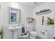 Cozy bathroom featuring a pedestal sink and decorative seashell-framed mirror adding coastal charm at 800 N Tamiami Trl # 604, Sarasota, FL 34236