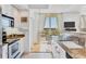 Bright kitchen with granite countertops, white cabinetry, and a view to the lanai through sheer window coverings at 800 N Tamiami Trl # 604, Sarasota, FL 34236