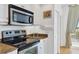 Close up of a stainless steel oven and cooktop with white cabinets and granite countertops in this well-lit kitchen at 800 N Tamiami Trl # 604, Sarasota, FL 34236