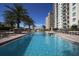 Inviting pool area featuring clear blue water, poolside seating, and pergola at 800 N Tamiami Trl # 604, Sarasota, FL 34236