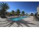 Resort-style pool surrounded by lounge chairs and lush palm trees on a sunny day at 800 N Tamiami Trl # 604, Sarasota, FL 34236