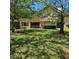 View of the back of a residential building with green grass and mature trees at 8110 Villa Grande Ct, Sarasota, FL 34243