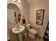 Cozy powder room featuring a pedestal sink, decorative painting, and ceramic tile flooring at 8110 Villa Grande Ct, Sarasota, FL 34243