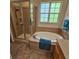Bathroom with walk-in shower, soaking tub, tile surround and window at 8110 Villa Grande Ct, Sarasota, FL 34243