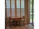 Charming breakfast nook with a round wooden table, chairs, and large window with plantation shutters at 8110 Villa Grande Ct, Sarasota, FL 34243