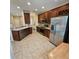Spacious kitchen with stainless steel appliances, dark wood cabinetry, tile backsplash, and tile floors at 8110 Villa Grande Ct, Sarasota, FL 34243