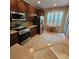 Well-lit kitchen featuring stainless steel appliances, wood cabinetry, and breakfast nook with shuttered window at 8110 Villa Grande Ct, Sarasota, FL 34243