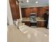 Kitchen area with stainless steel appliances, wood cabinetry, tile floors, and a cream colored countertop at 8110 Villa Grande Ct, Sarasota, FL 34243