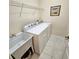 The laundry room features a utility sink, washer, dryer, wire shelf, and tile flooring at 8110 Villa Grande Ct, Sarasota, FL 34243