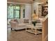 Cozy living room with tile floors, white sofas, stone accent wall, and sliding glass doors to the porch at 8110 Villa Grande Ct, Sarasota, FL 34243