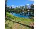 Beautiful view of the serene community pond with lush green grass and mature trees at 8110 Villa Grande Ct, Sarasota, FL 34243