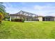 A screened-in lanai extends from this home's backyard, which features lush green grass and well-maintained landscaping at 8118 Stirling Falls Cir, Sarasota, FL 34243