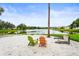 Picturesque beach area features colorful Adirondack chairs, soft sand, and a serene lake view with lush landscaping at 8118 Stirling Falls Cir, Sarasota, FL 34243