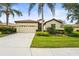 Charming single-story home features a well-manicured lawn, two-car garage, and lush tropical landscaping at 8118 Stirling Falls Cir, Sarasota, FL 34243