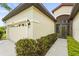 Beige home with well-manicured landscaping, two-car garage, red tile roof, and a secure front gate at 8118 Stirling Falls Cir, Sarasota, FL 34243