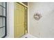 Welcoming yellow front door adorned with a seashell wreath and sidelights, enhancing curb appeal at 8118 Stirling Falls Cir, Sarasota, FL 34243