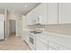 Bright white kitchen features matching appliances and countertops with tile flooring and ample storage at 8118 Stirling Falls Cir, Sarasota, FL 34243