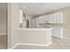 Spacious kitchen with white cabinets and breakfast bar with tile flooring and access to the living room at 8118 Stirling Falls Cir, Sarasota, FL 34243