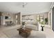 Open-concept living room with neutral tones, tile flooring, and seamless transition to kitchen and dining areas at 8118 Stirling Falls Cir, Sarasota, FL 34243