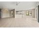 Open living room features tile flooring and transitions to kitchen, with natural light and neutral paint at 8118 Stirling Falls Cir, Sarasota, FL 34243