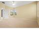 A bright and airy main bedroom with neutral carpet, multiple windows, and a ceiling fan at 8118 Stirling Falls Cir, Sarasota, FL 34243