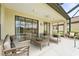 Comfortable covered patio with seating, a ceiling fan, and views of the backyard and lake beyond at 8118 Stirling Falls Cir, Sarasota, FL 34243