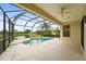 Screened-in pool area featuring tranquil lake views, beautiful landscaping, and ceiling fan at 8118 Stirling Falls Cir, Sarasota, FL 34243