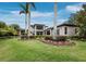 Expansive backyard with meticulous landscaping, mature trees, and a view of the home at 8316 Portlight Ct, Lakewood Ranch, FL 34202