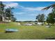 Beautiful backyard with lush green grass and water view; features two cornhole boards at 8316 Portlight Ct, Lakewood Ranch, FL 34202