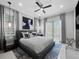 Well-lit main bedroom with cool colors, contemporary ceiling fan, and stylish decor for a restful retreat at 8316 Portlight Ct, Lakewood Ranch, FL 34202