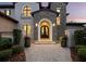 Close-up of an elegant front entrance with an arched stone doorway and custom iron door at 8316 Portlight Ct, Lakewood Ranch, FL 34202