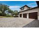 This exterior home elevation showcases a spacious driveway and attached three car garage at 8316 Portlight Ct, Lakewood Ranch, FL 34202