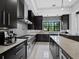 Modern kitchen with stainless appliances, sleek black cabinetry, and granite countertops at 8316 Portlight Ct, Lakewood Ranch, FL 34202