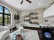Bright living room with a game table, built-in shelving, and arched window at 8316 Portlight Ct, Lakewood Ranch, FL 34202