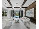 The spacious living room features an elegant chandelier, lots of seating, and a view of the outdoor pool at 8316 Portlight Ct, Lakewood Ranch, FL 34202