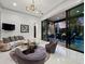 Living room with contemporary seating, marble tables, and a large sliding glass door to the patio at 8316 Portlight Ct, Lakewood Ranch, FL 34202