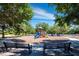 Playground area with colorful slides and climbing structures surrounded by shady trees at 8316 Portlight Ct, Lakewood Ranch, FL 34202