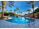 Community pool with water feature, mature palm trees and plenty of space for lounge chairs at 8316 Portlight Ct, Lakewood Ranch, FL 34202