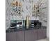 Marble wet bar with bottle storage and dark countertop at 8316 Portlight Ct, Lakewood Ranch, FL 34202