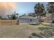 Backyard view featuring tropical palm trees, lush grass, and a modern wooden fence for added privacy at 904 Winter Garden Dr, Sarasota, FL 34243
