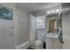 Bright bathroom with tiled shower, white fixtures, and decor at 904 Winter Garden Dr, Sarasota, FL 34243