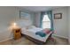 Cozy bedroom with a bed, bedside table, window, and curtains at 904 Winter Garden Dr, Sarasota, FL 34243
