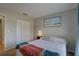 Neutral bedroom featuring a bed with a colorful throw, a closet, and wall art at 904 Winter Garden Dr, Sarasota, FL 34243