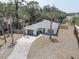 Beautiful single-story home with gray roof and driveway, complemented by the lush greenery of surrounding palm trees at 904 Winter Garden Dr, Sarasota, FL 34243