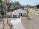 Charming single-story home with a gray roof, a gray garage door, and a long driveway with palm trees at 904 Winter Garden Dr, Sarasota, FL 34243