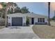 Charming single-story home with a gray roof, gray garage door, and a well-maintained front yard at 904 Winter Garden Dr, Sarasota, FL 34243