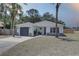 Inviting exterior showcasing a well-manicured lawn and a charming one-story home with a gray roof at 904 Winter Garden Dr, Sarasota, FL 34243