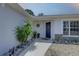 Close-up of front porch with neat garden, pathway, and dark-blue front door at 904 Winter Garden Dr, Sarasota, FL 34243