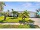 Charming home with tropical landscaping including mature palm trees and well-maintained lawn at 913 64Th W St, Bradenton, FL 34209